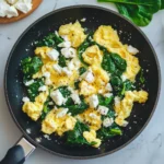 whisked eggs, sautéing spinach, adding feta