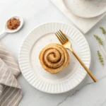 Keto Cinnamon Roll: The Ultimate Low-Carb Delight You’ll Love 8 Spreading cream cheese frosting on warm keto cinnamon rolls
