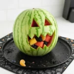 Scoop of fruit from a watermelon monster for halloween appetizers
