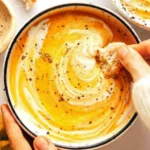 Healthy Roasted Vegetable Soup with crusty bread on marble