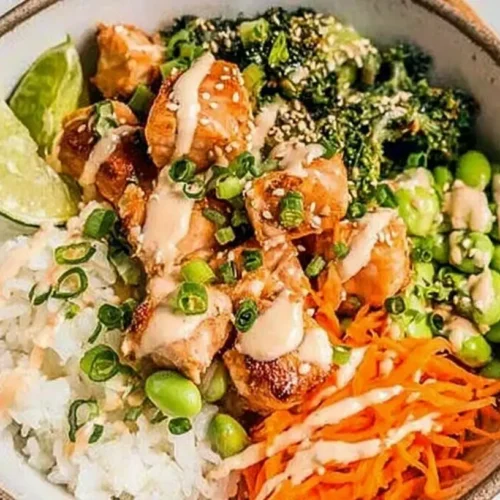 A vibrant crispy salmon rice bowl served with fresh vegetables and sauce.