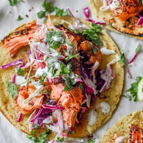 Salmon Tacos: 5 Recipes You Need 2 A plate of fresh salmon tacos garnished with lime and cilantro.