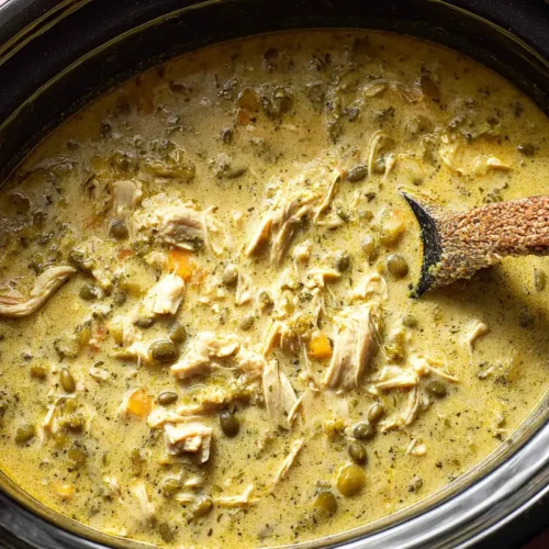Crock Pot Green Enchilada Chicken Soup: 3 Secrets 2 A steaming bowl of crock pot green enchilada chicken soup garnished with fresh cilantro and a dollop of sour cream.
