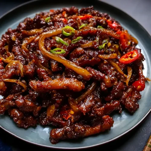 Crispy Chilli Beef: Top 10 Tips for Flavor 2 A plate of crispy chilli beef with a glossy sauce.