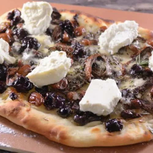 Close-up of crispy flatbread with melted brie cheese and dried cranberries