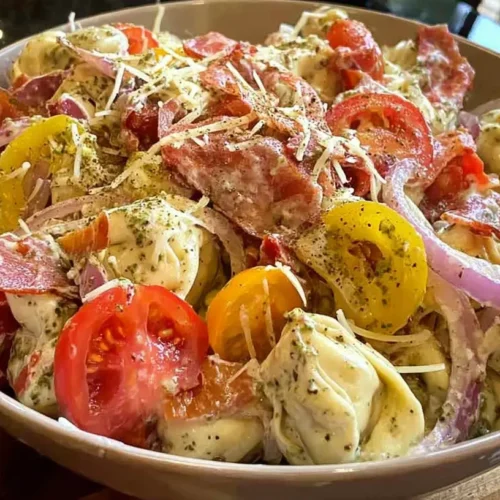 A vibrant grinder tortellini salad with various vegetables and meats.