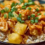 Close-up of pineapple chicken and rice, featuring juicy chicken pieces and tangy pineapple.