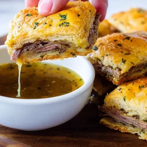 A platter of savory French Dip Squares with melted cheese and beef.