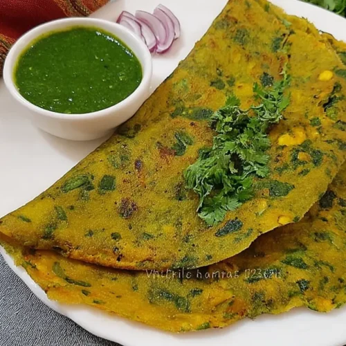 A freshly made palak chilla recipe served with chutney on a plate