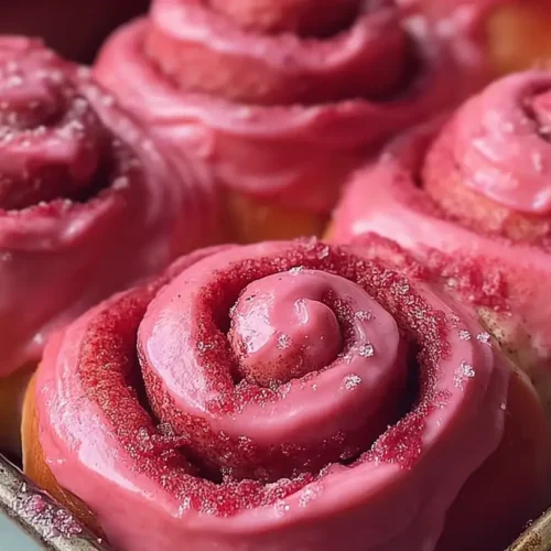 Pink Velvet Cinnamon Rolls: How Many Can You Eat? 2 Freshly baked pink velvet cinnamon rolls artfully arranged.