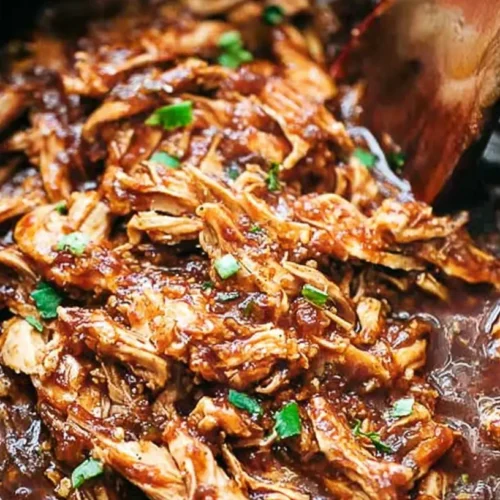 A crockpot full of honey garlic chicken, ready to serve