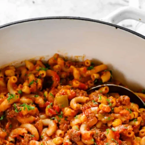 A steaming bowl of hearty American goulash with pasta and meat