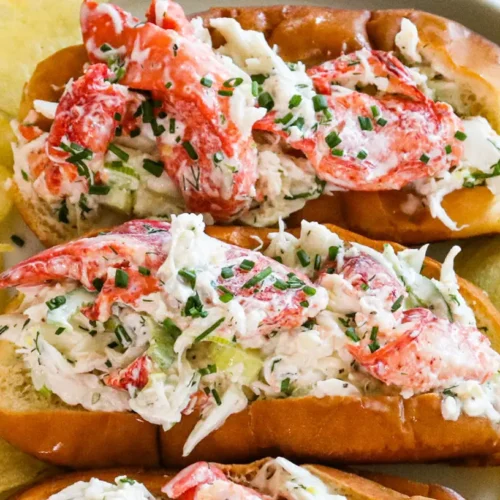 A freshly prepared Maine crab roll on a toasted bun, garnished with a lemon wedge