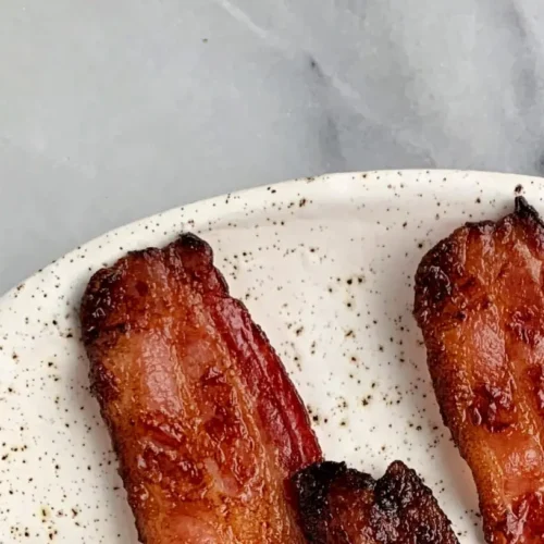 Strips of oven baked crispy bacon on a sheet pan