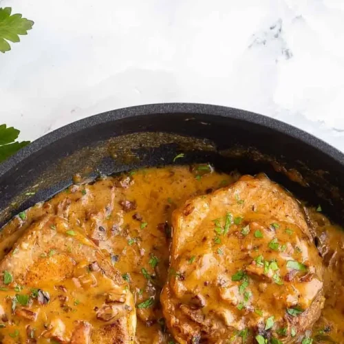 A plate of rich smothered pork chops with gravy